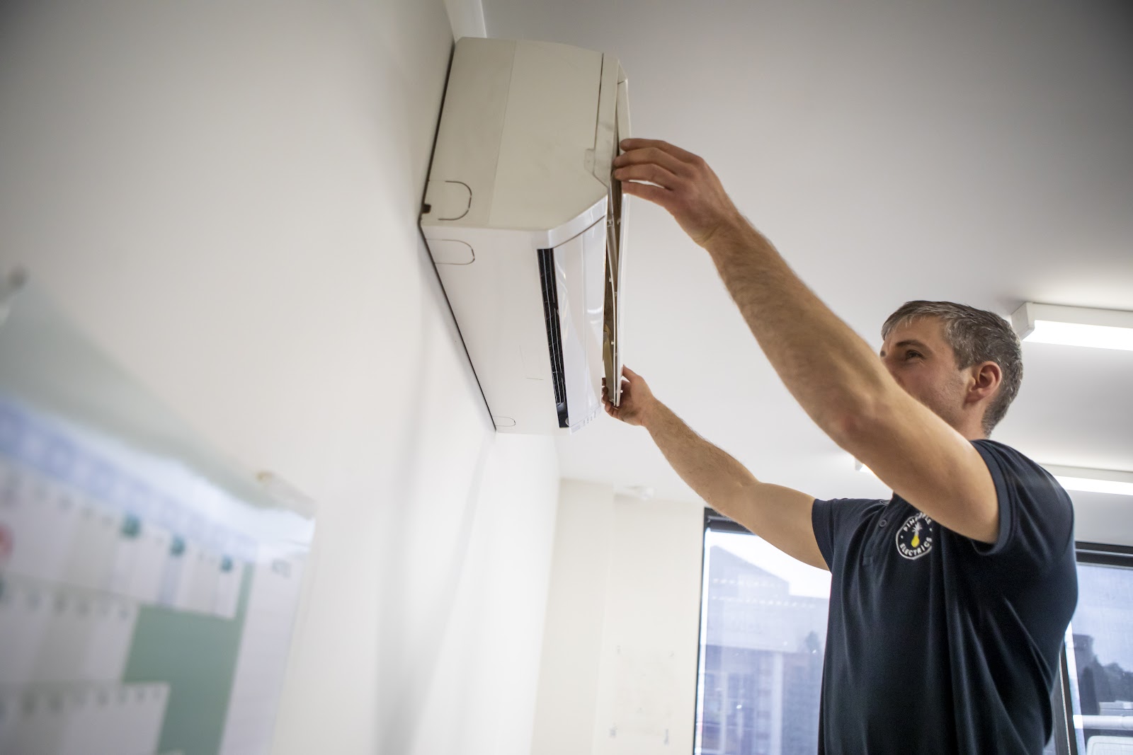 Jordan fitting a split system wall unit in an office
