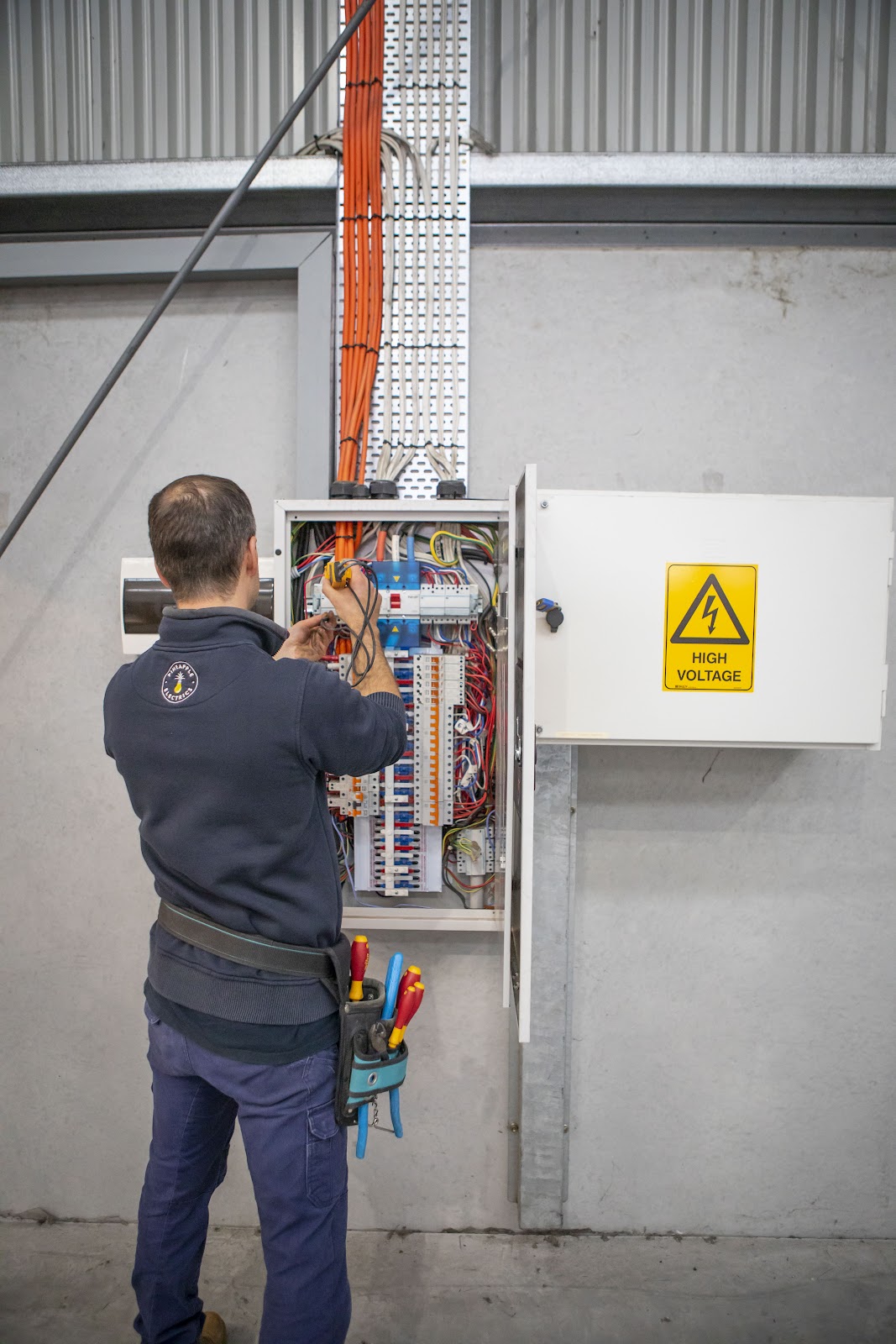 Jordan working inside a large industrial switchboard
