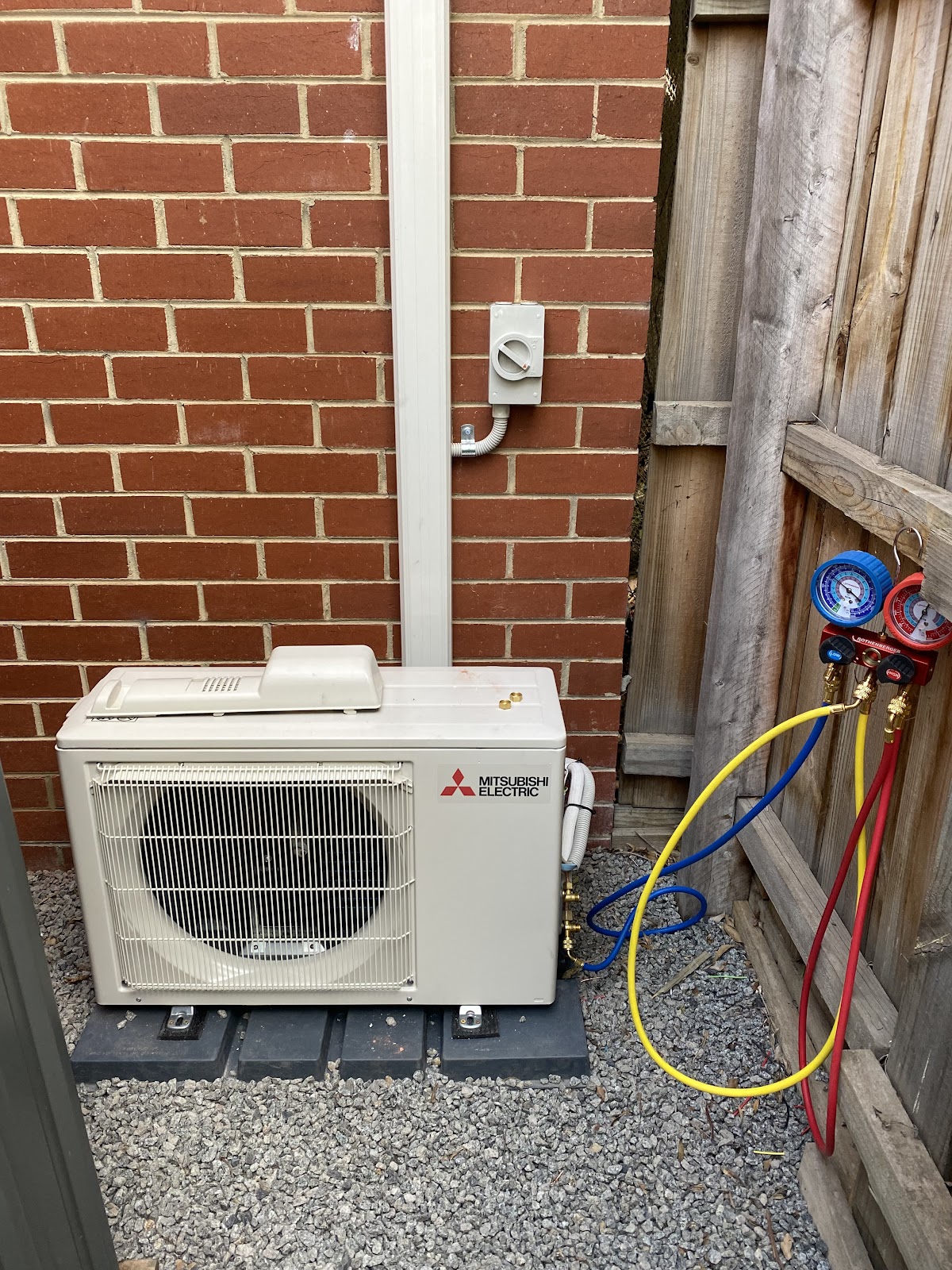 Mitsubishi Electric outdoor unit with gauges connected during commissioning